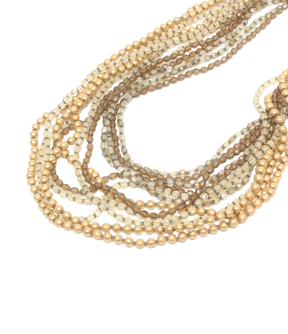 Collana multifilo Maria Calderara di perline sfaccettate e sfere opache color oro, dal champagne al bruno, su fondo bianco