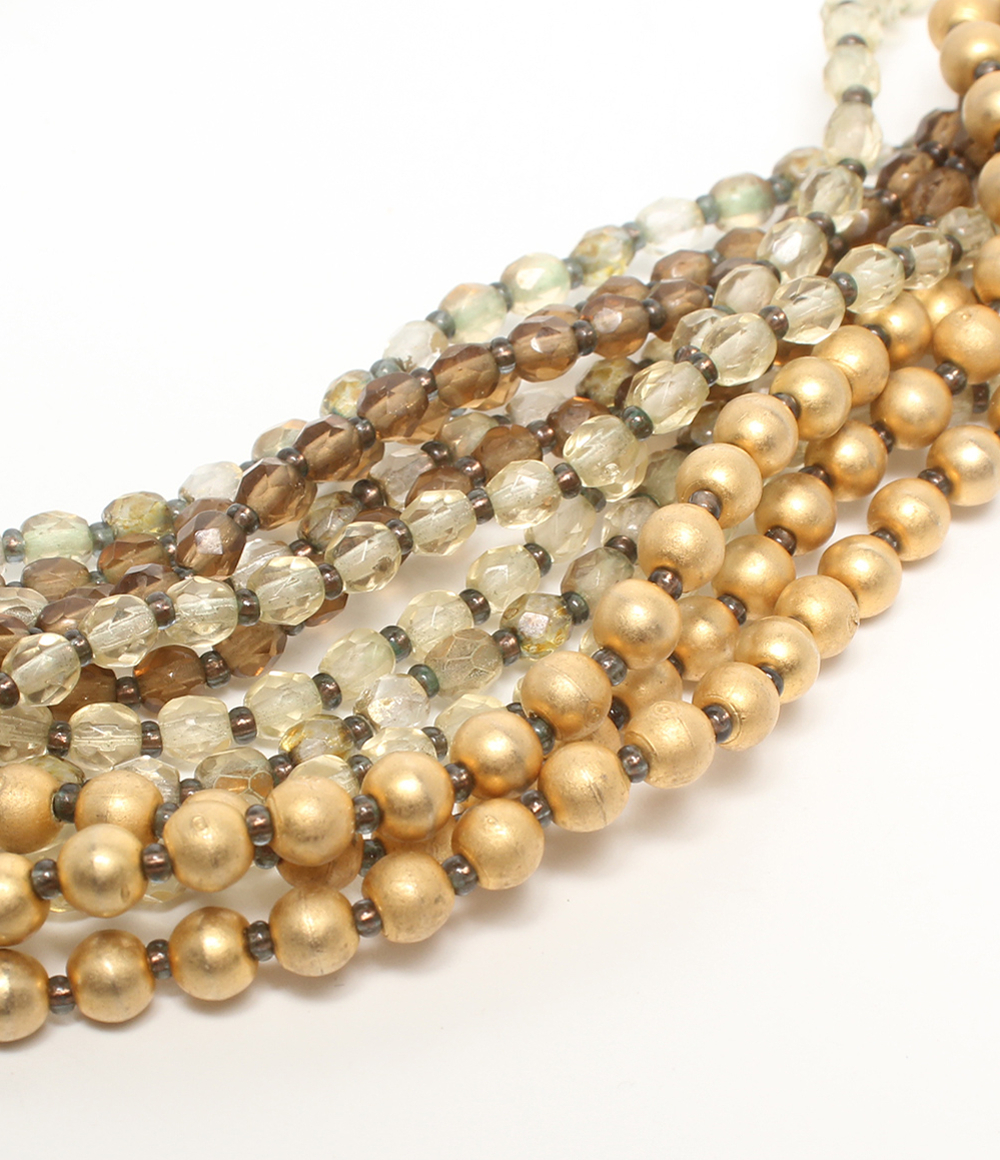 Collana multifilo Maria Calderara di perline sfaccettate e sfere opache color oro, dal champagne al bruno, su fondo bianco — vista 6