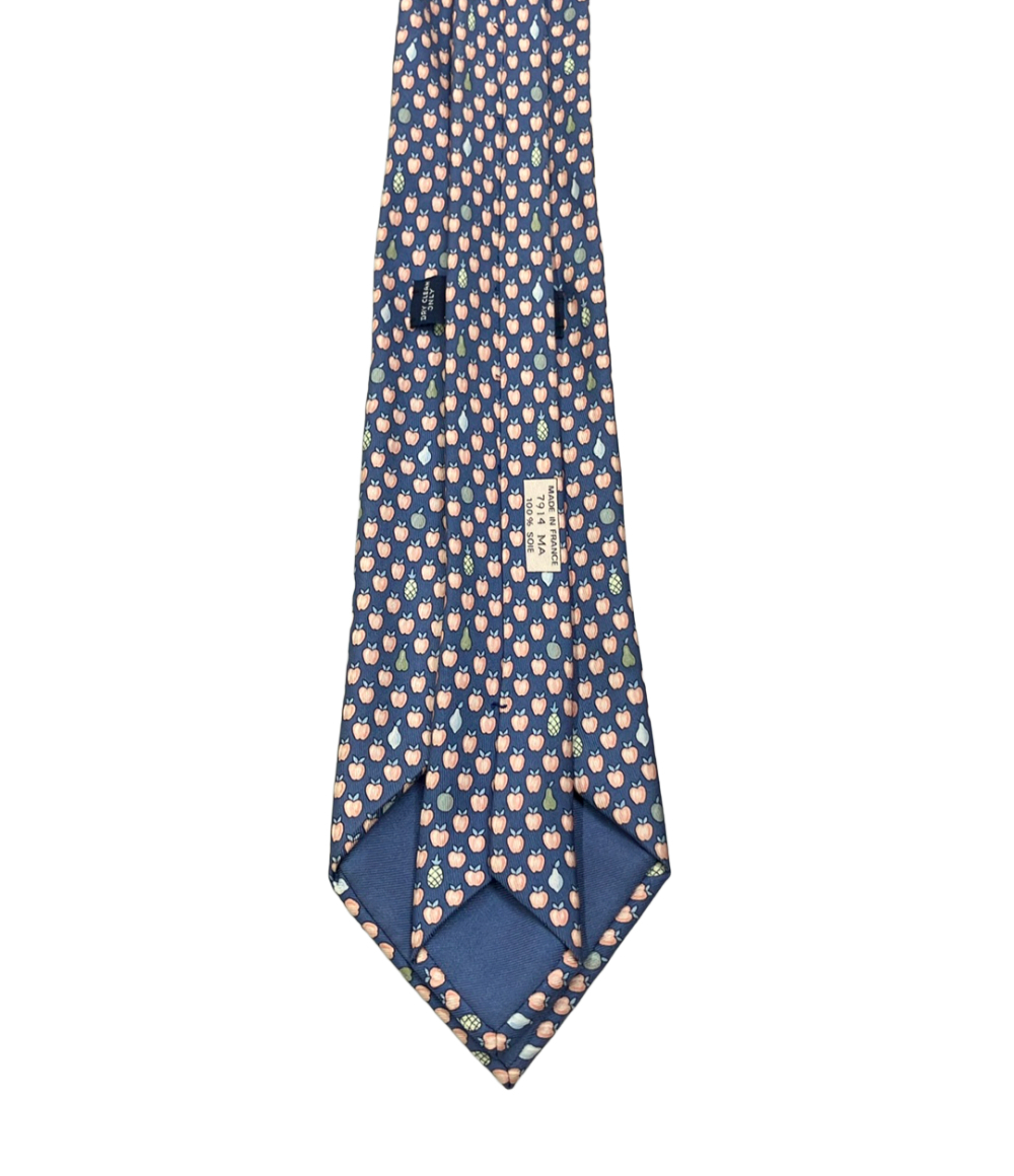 Cravatta Hermès in seta blu a piccole mele color pesca, con pere e ananas sparsi, ripiegata su fondo bianco — vista 3
