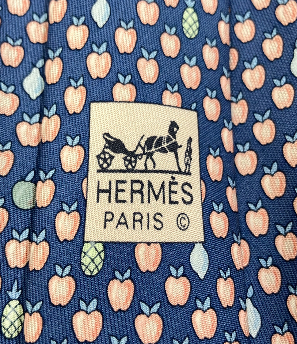 Cravatta Hermès in seta blu a piccole mele color pesca, con pere e ananas sparsi, ripiegata su fondo bianco — vista 4