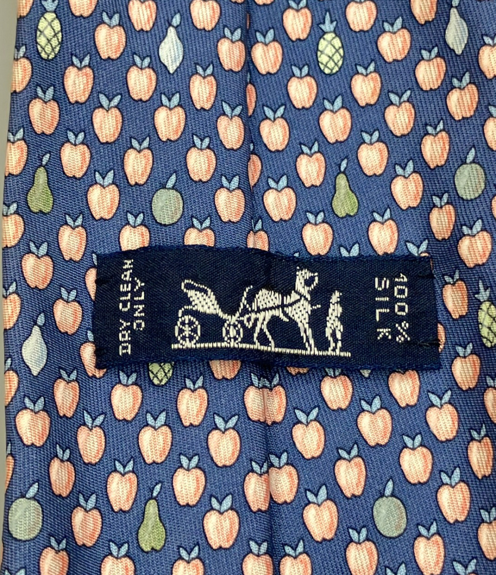 Cravatta Hermès in seta blu a piccole mele color pesca, con pere e ananas sparsi, ripiegata su fondo bianco — vista 5