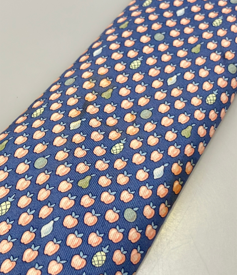 Cravatta Hermès in seta blu a piccole mele color pesca, con pere e ananas sparsi, ripiegata su fondo bianco — vista 6