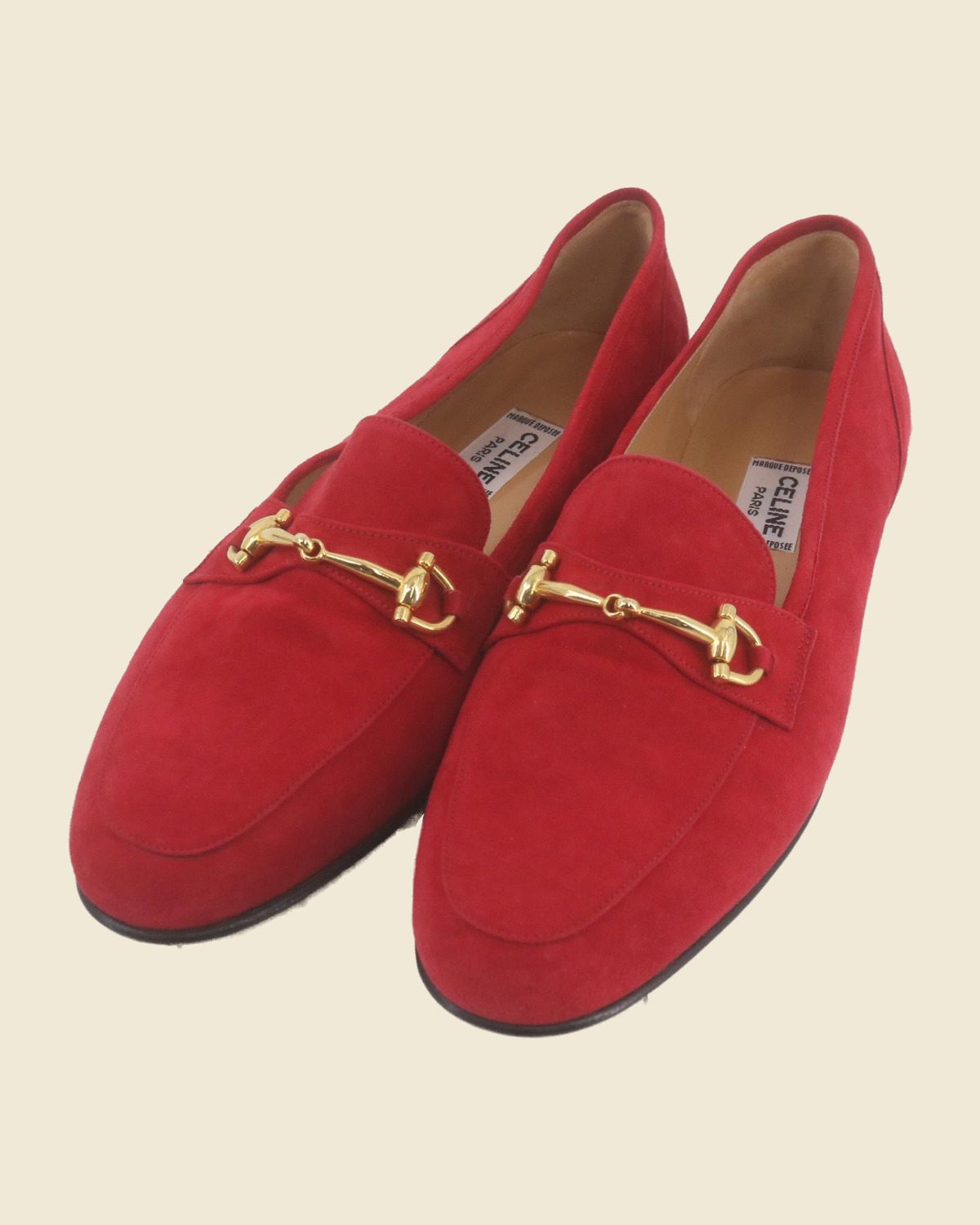 Mocassini Celine in camoscio rosso con morsetto dorato.